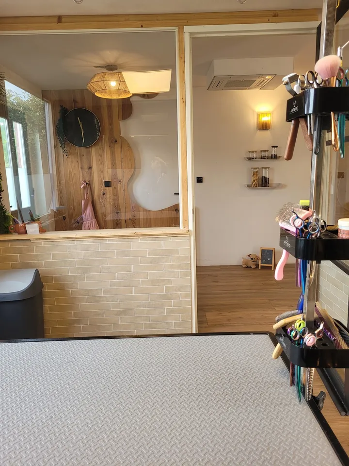 Zicht vanaf de trimtafel door de glazen wand de salon in